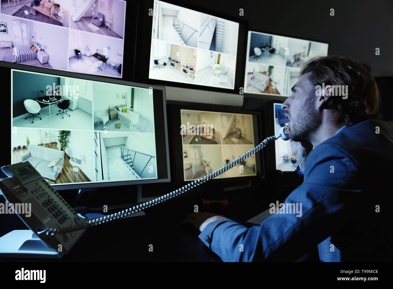 Security guard monitoring modern CCTV cameras in surveillance room