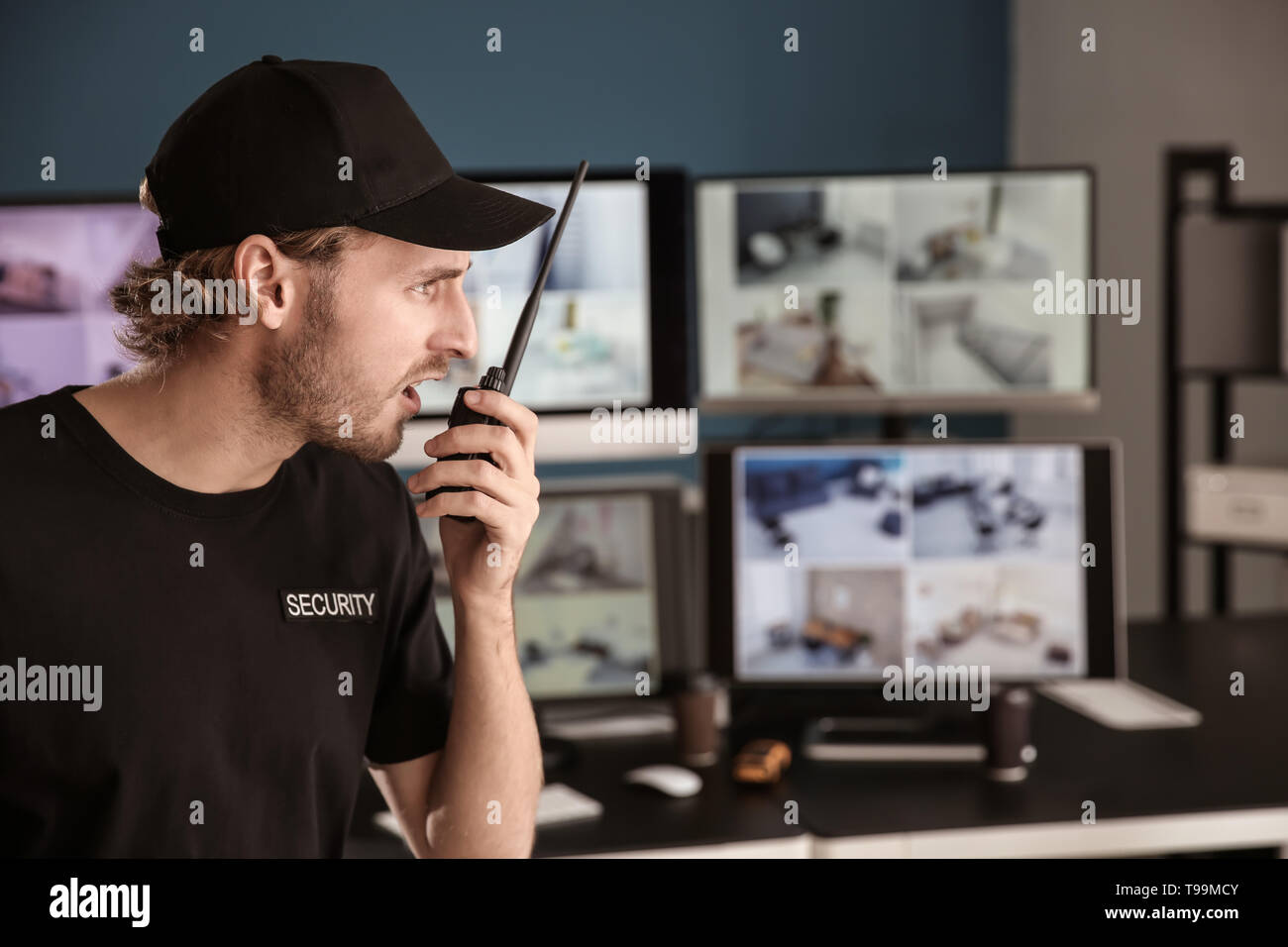 Security guard with portable radio transmitter in surveillance room