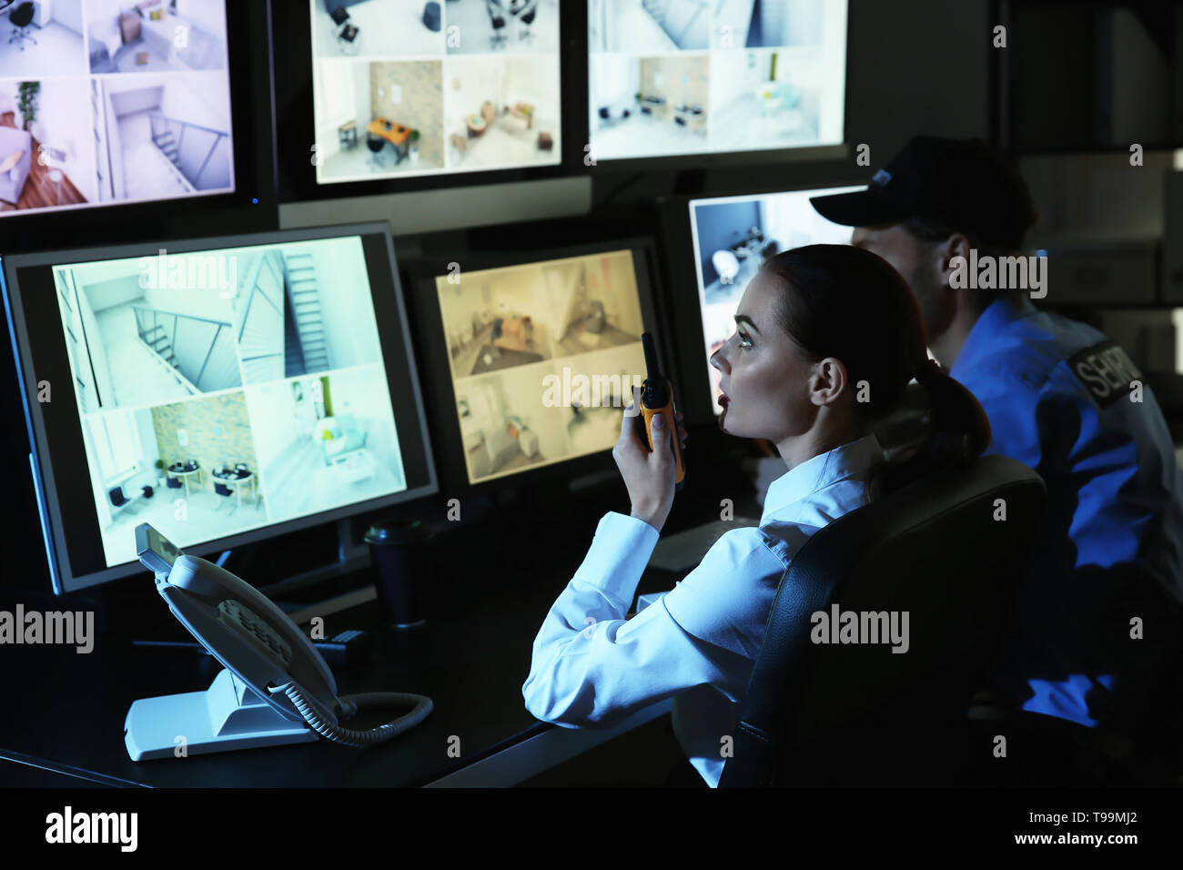 Security guards monitoring modern CCTV cameras in surveillance room