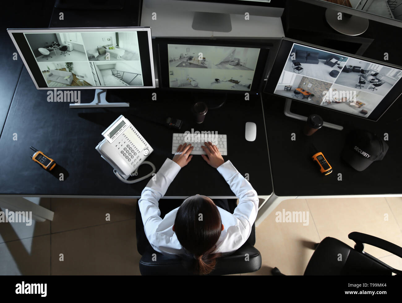 Security guard monitoring modern CCTV cameras in surveillance room