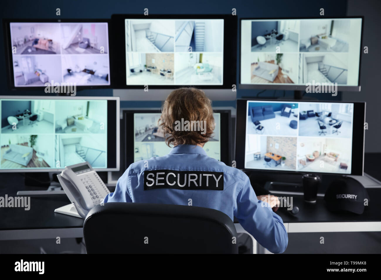 Security guard monitoring modern CCTV cameras in surveillance room