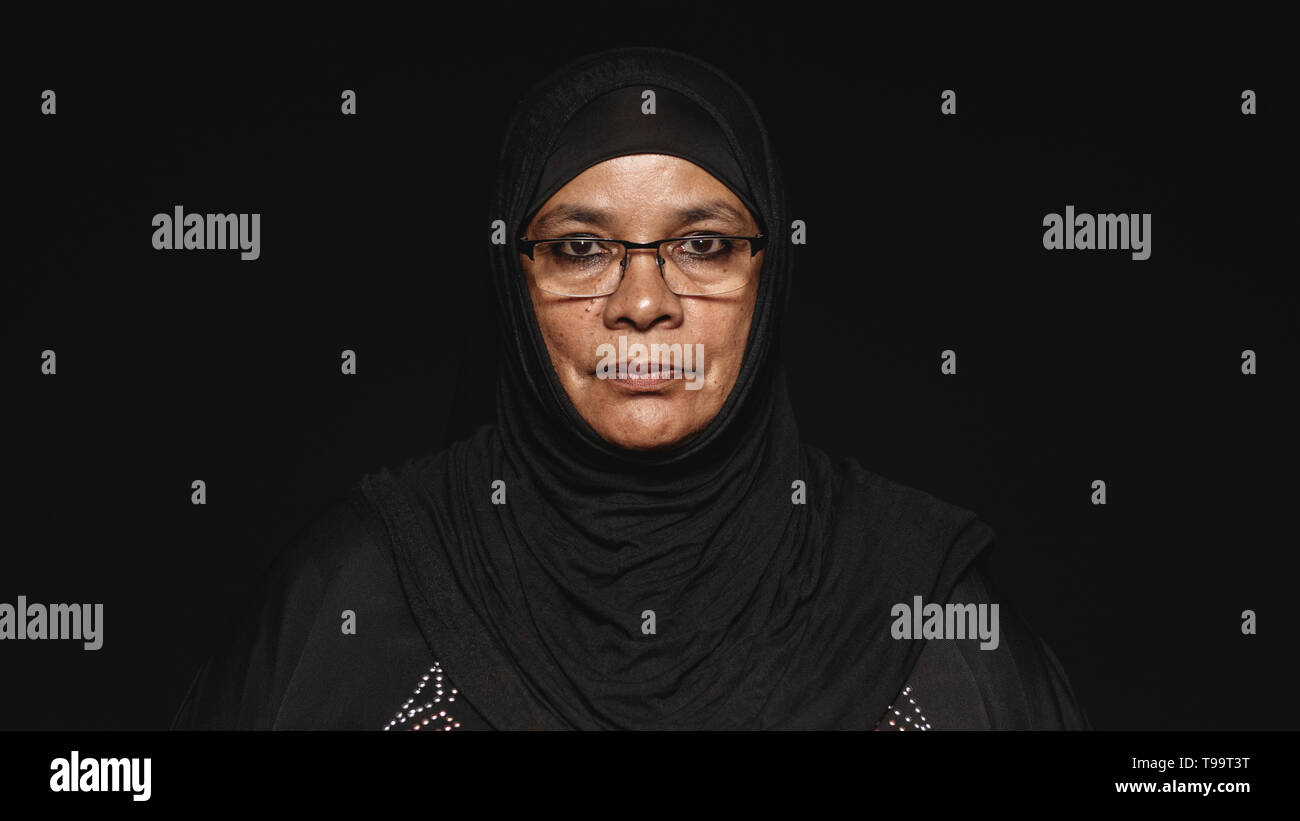 Close up of a muslim woman in hijab isolated on black background ...