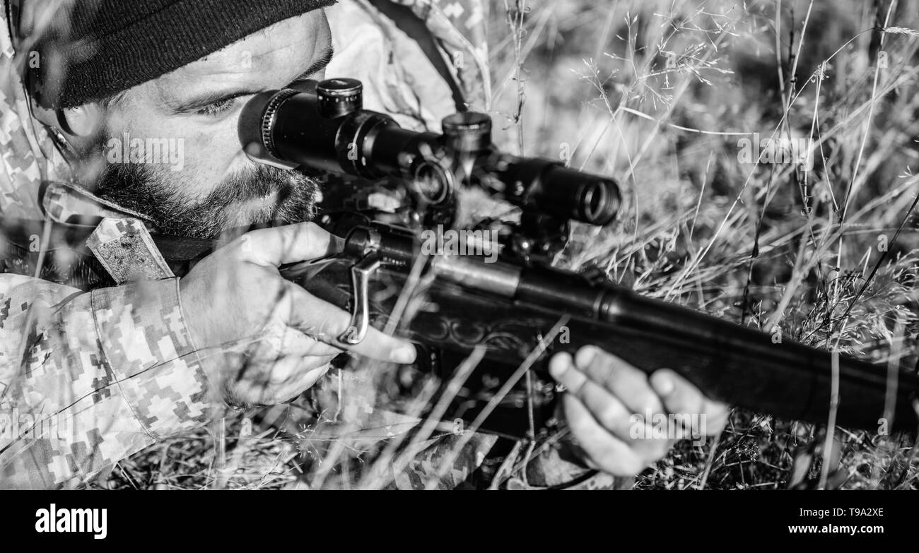 Man hunter with rifle gun. Boot camp. Bearded man hunter. Army forces. Camouflage. Military uniform fashion. Hunting skills and weapon equipment. How turn hunting into hobby. Strict verdict. Stock Photo