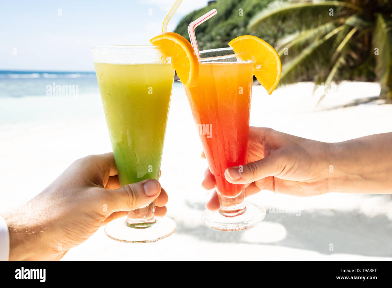 https://c8.alamy.com/comp/T9A3ET/close-up-of-couples-hand-toasting-the-glasses-of-cocktail-at-beach-during-summer-T9A3ET.jpg