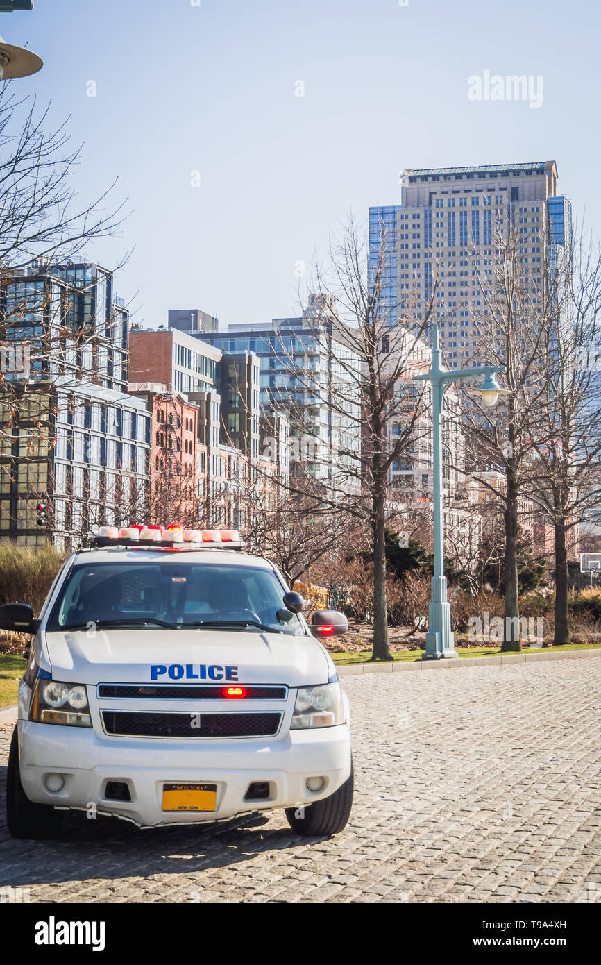 Lower New York Cityscape from the Hudson River docks with a police car NYPD Stock Photo
