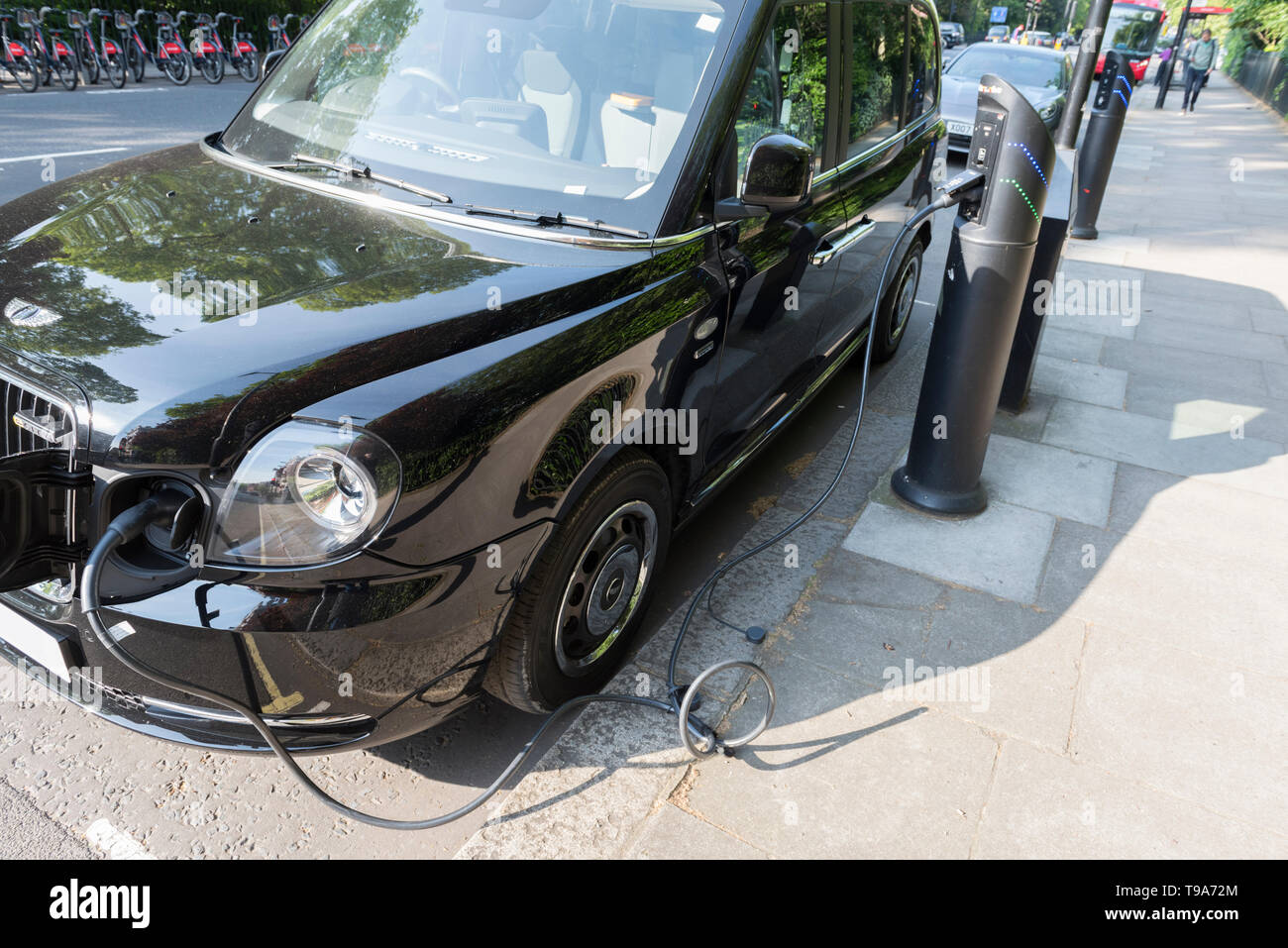 London Taxi Cab charging an internal battery at street side charging point in Eton Square, London, England, UK. Stock Photo