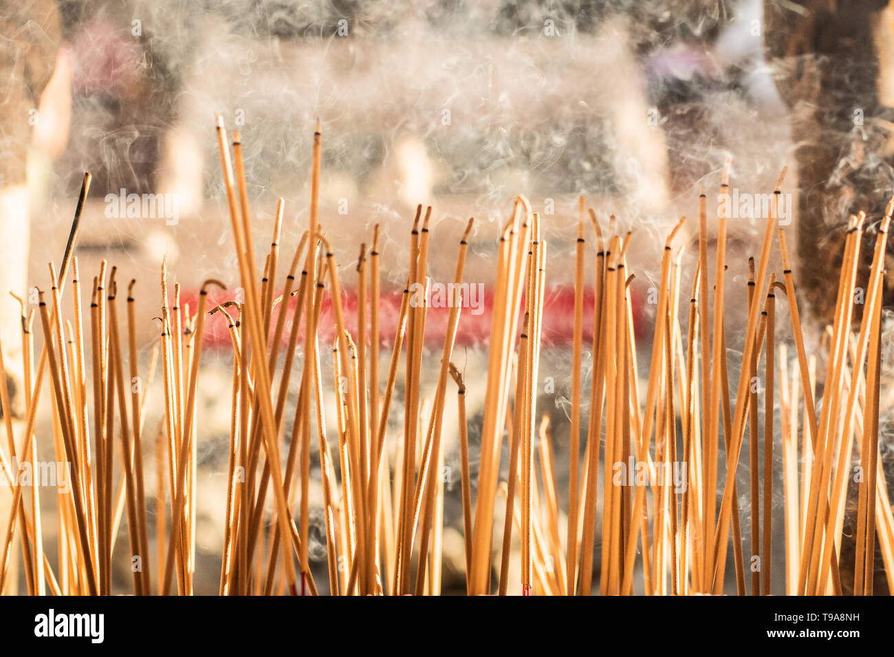joss sticks burning at a vintage Buddhist temple courtyard as offering