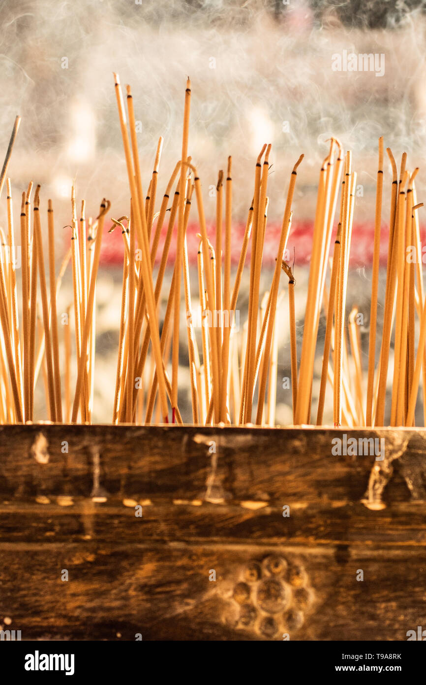 joss sticks burning at a vintage Buddhist temple courtyard as offering