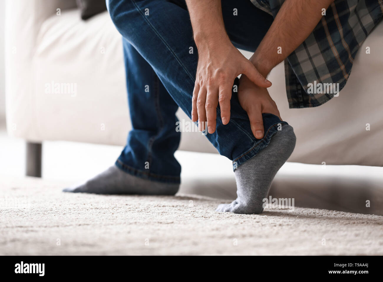 Man suffering from leg pain at home Stock Photo - Alamy