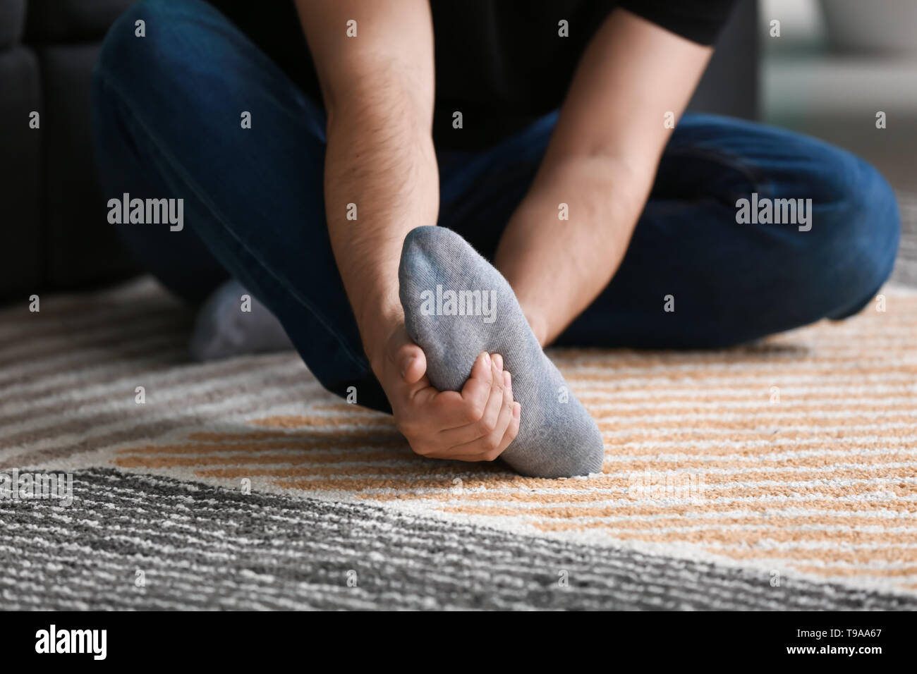 Man suffering from leg pain at home Stock Photo - Alamy