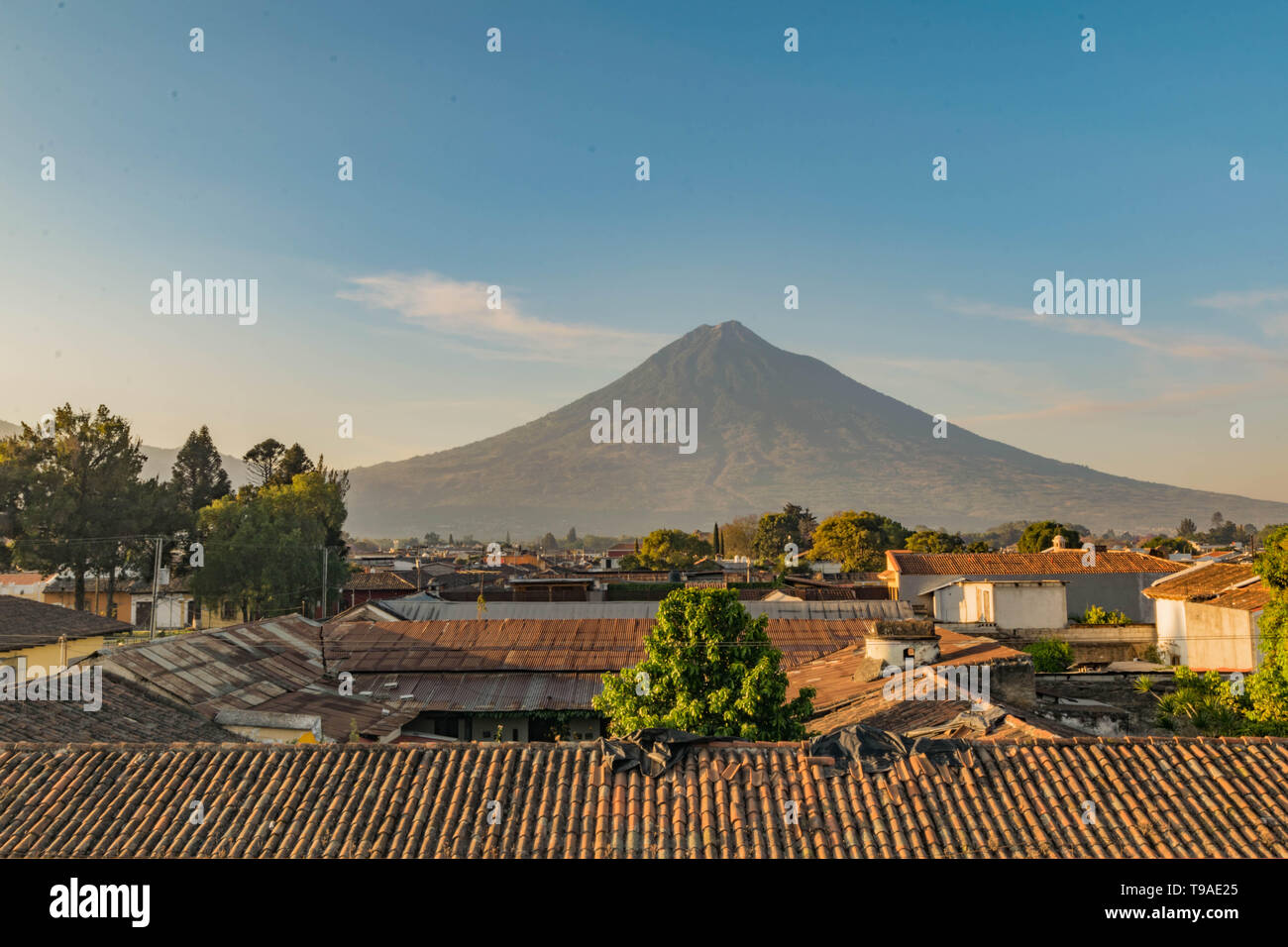 Looking across tiled rooftops with volcanoes in the distance, in Antigua, Guatemala Stock Photo