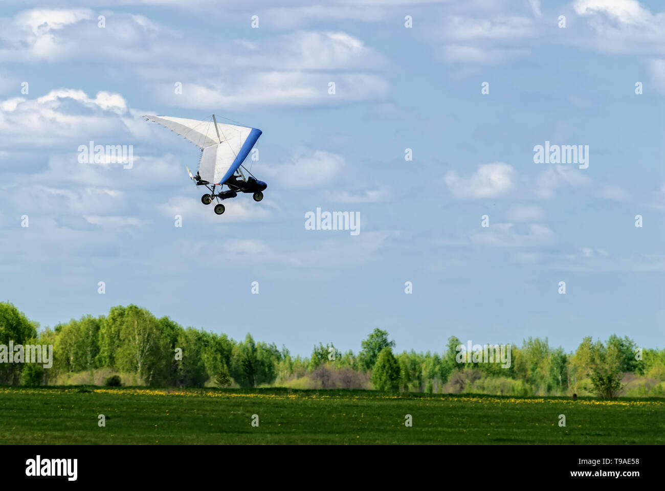 Yalutorovsk, Russia - May 24. 2008: The motorized hang glider above forest at sport airdrome Stock Photo