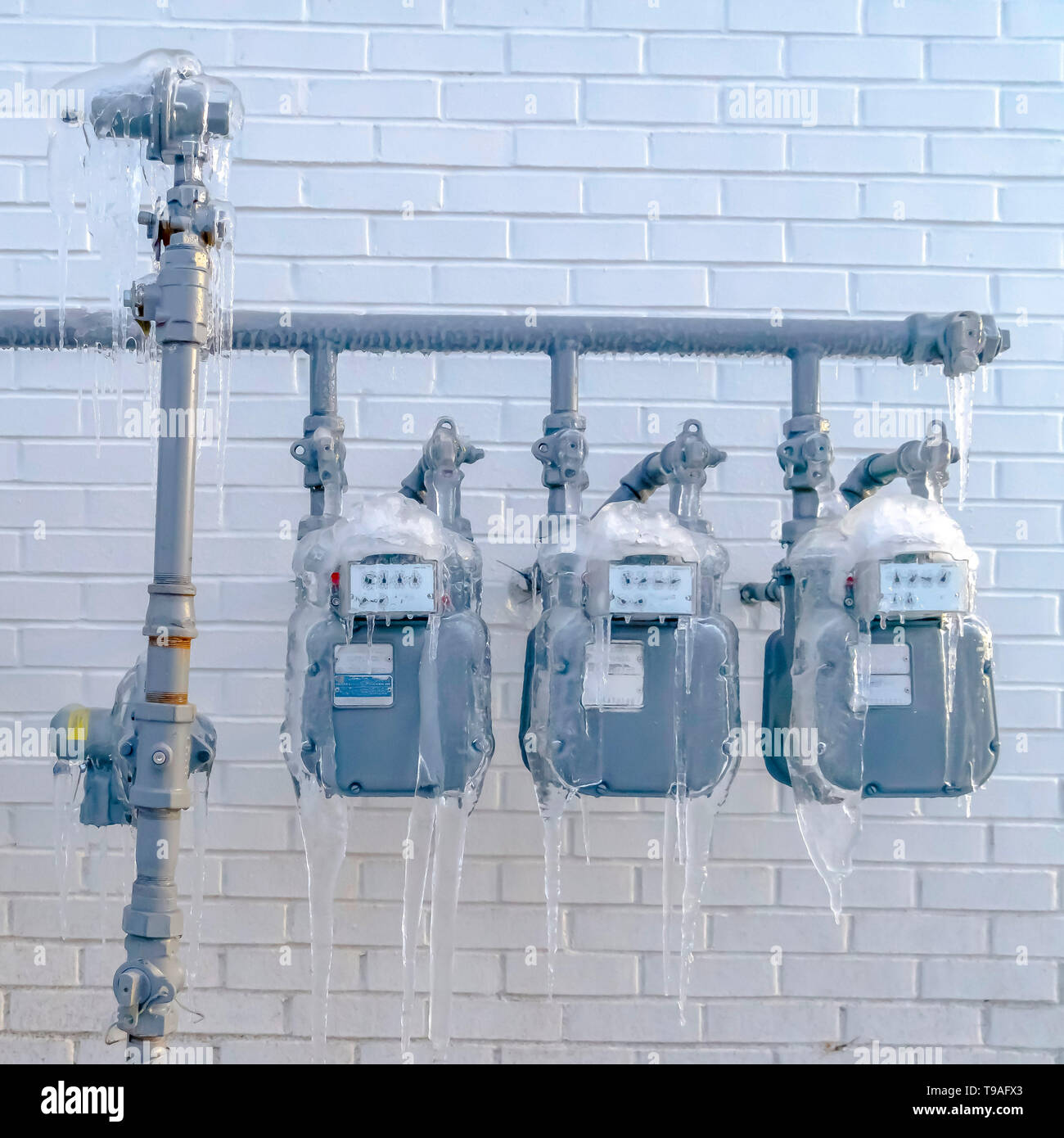 Clear Square Water meters and pipes covered with ice during winter in