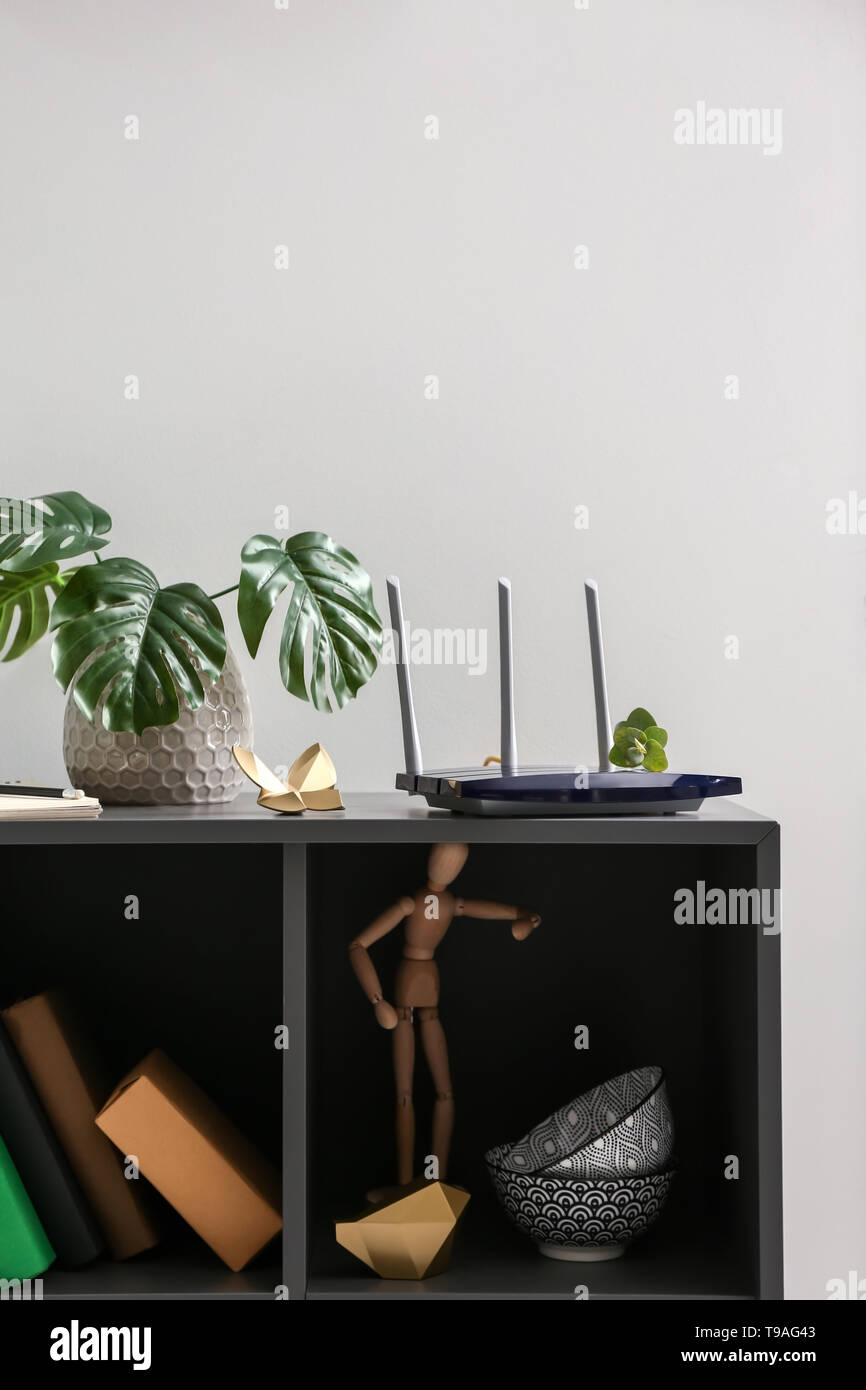 Modern wi-fi router on dark shelf Stock Photo - Alamy