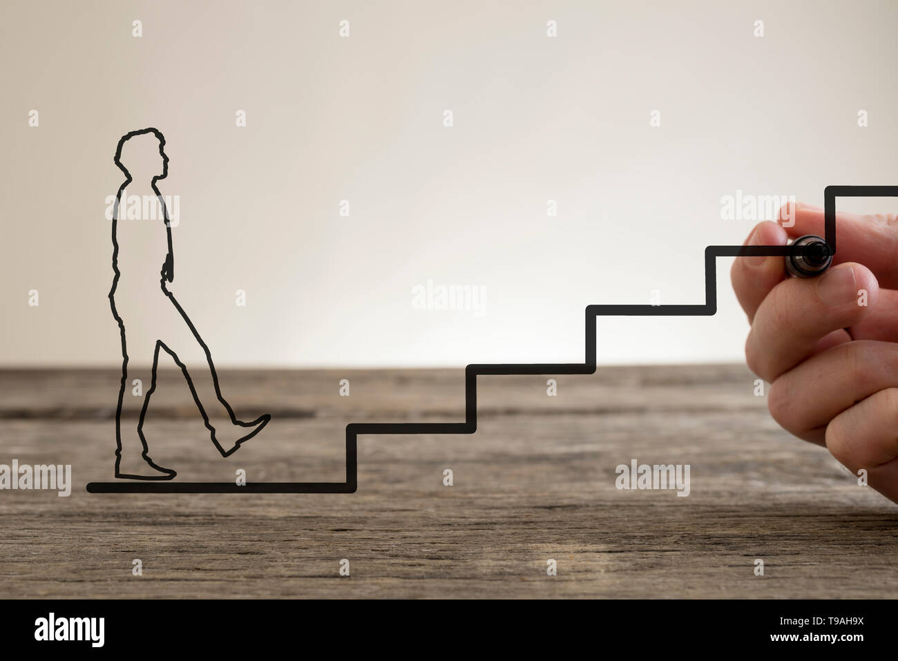 Man drawing the line of stairs with a marker pen for the outline of a businessman climbing towards business success, conceptual of partnership and tea Stock Photo