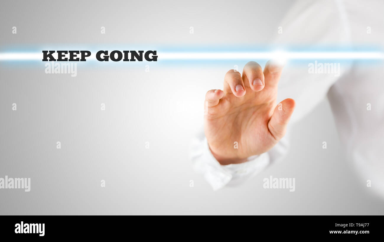 Motivational Image of Hand Touching Keep Going Statement on Touch Screen. Stock Photo