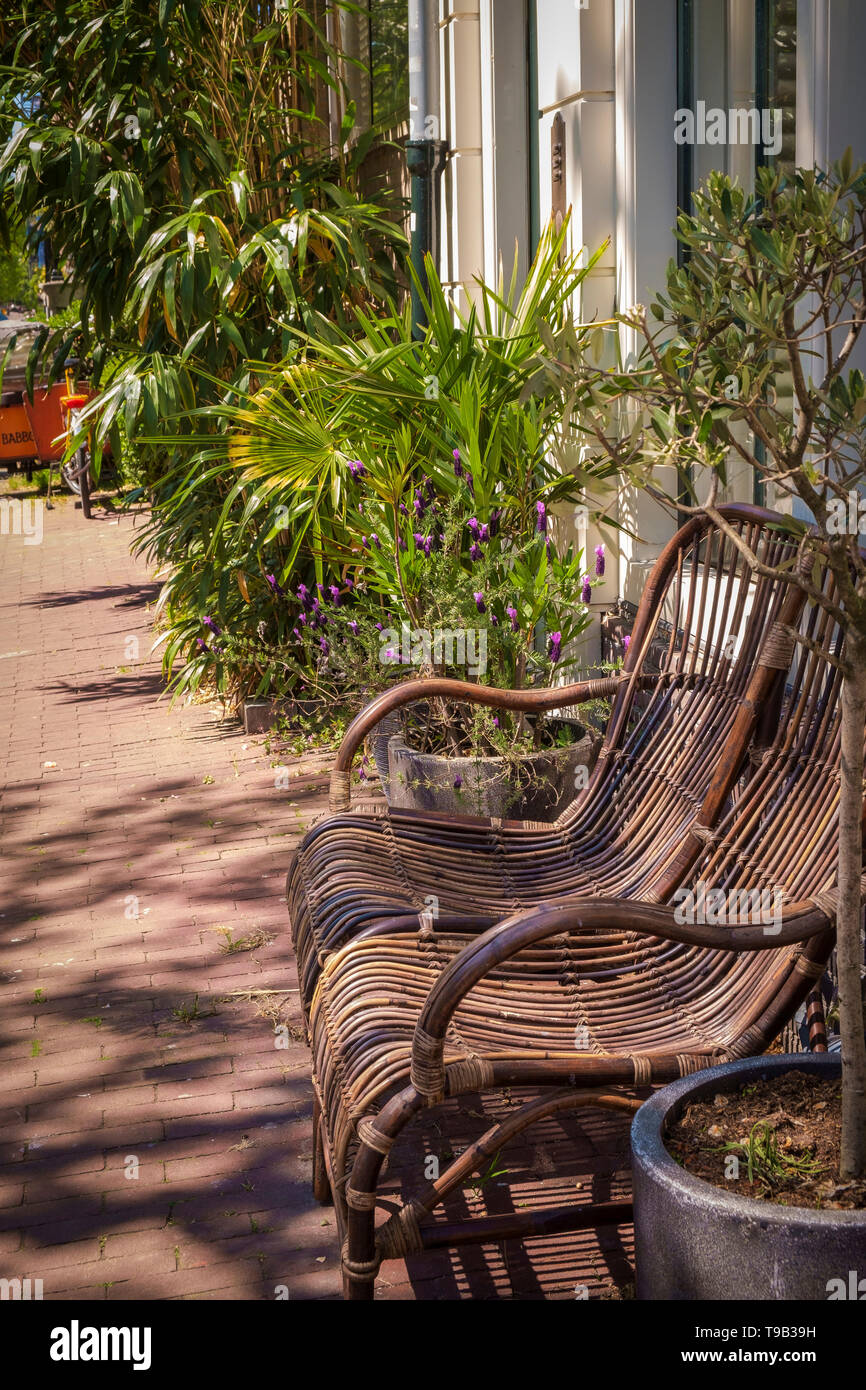 Outdoor rattan furniture and plants on the pavement in Amsterdam, The