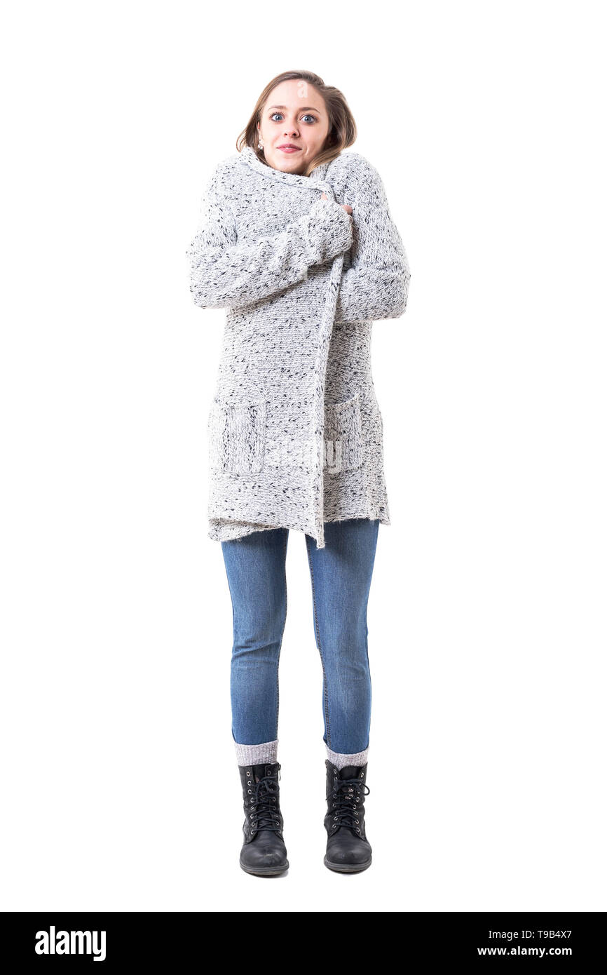 Freezing cold young woman covering with cardigan in winter fashion ...