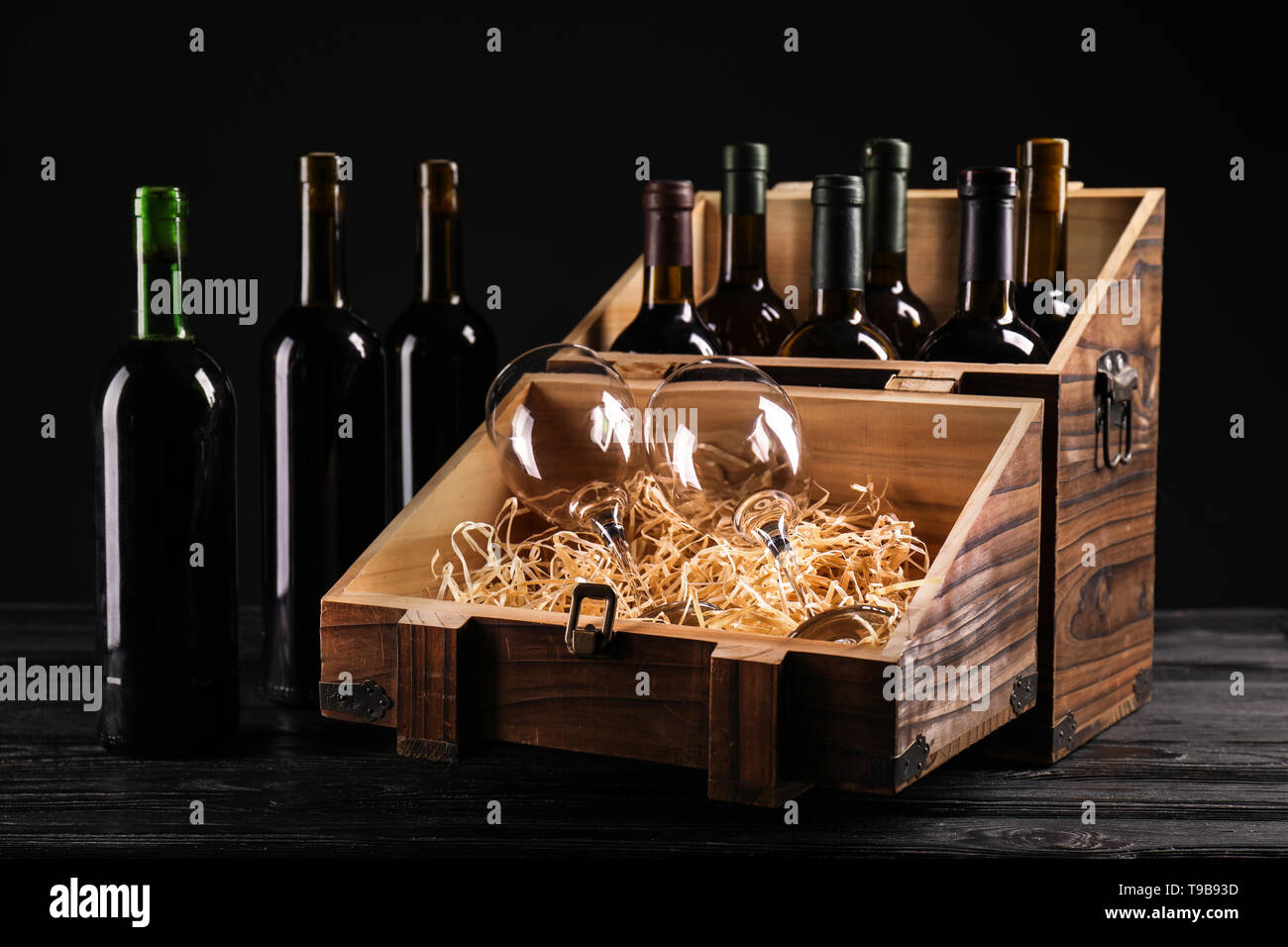 Wooden box with bottles of different wine and empty glasses on dark  background Stock Photo - Alamy, image size:1300x956