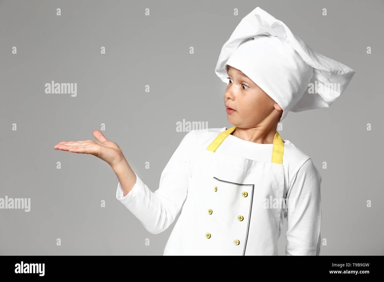 Cute little chef on grey background Stock Photo - Alamy