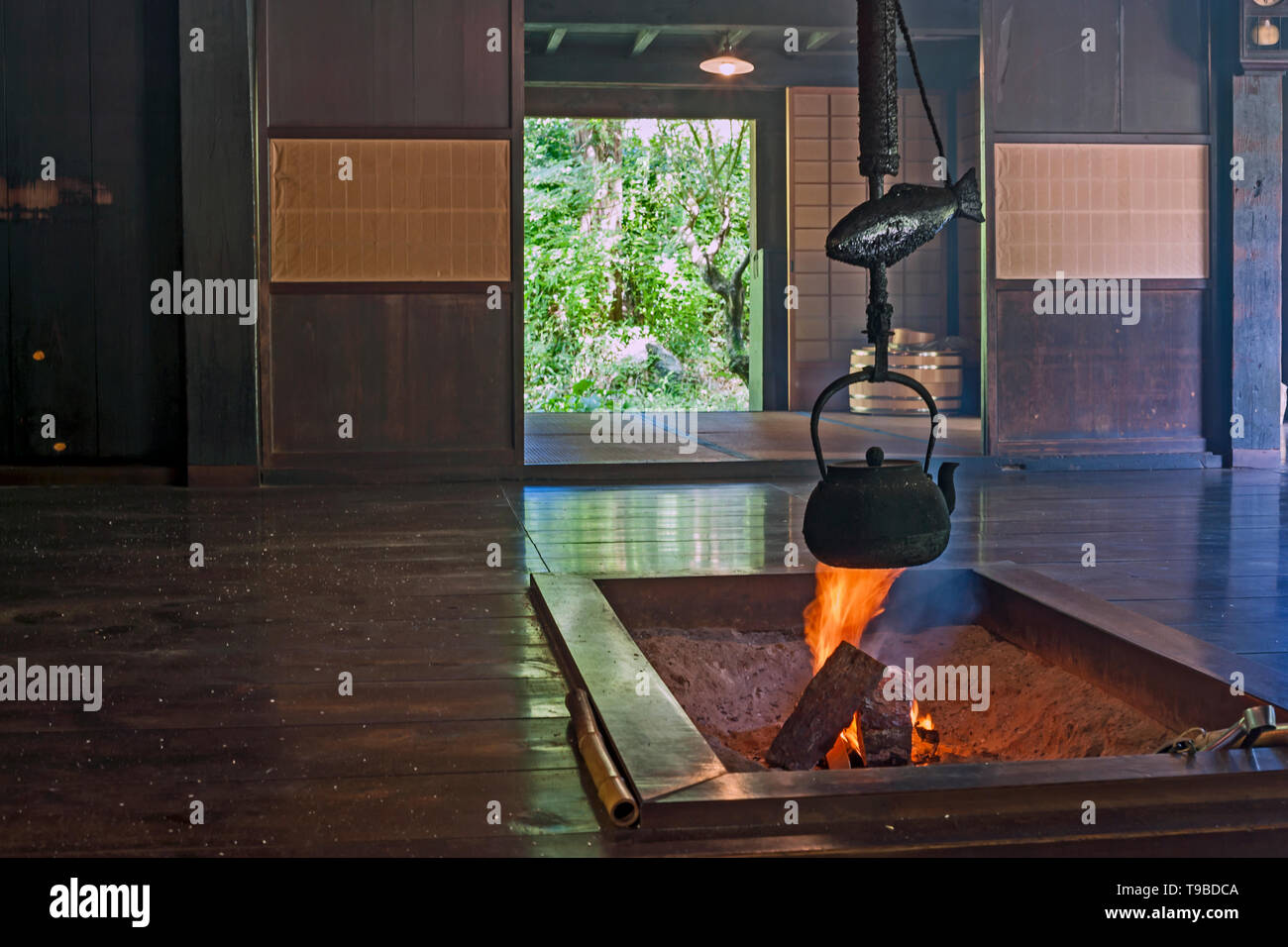 An old iron kettle hangs above an open fire inside the 19th century