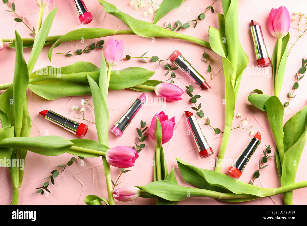 Beautiful tulips with different lipsticks on color background Stock