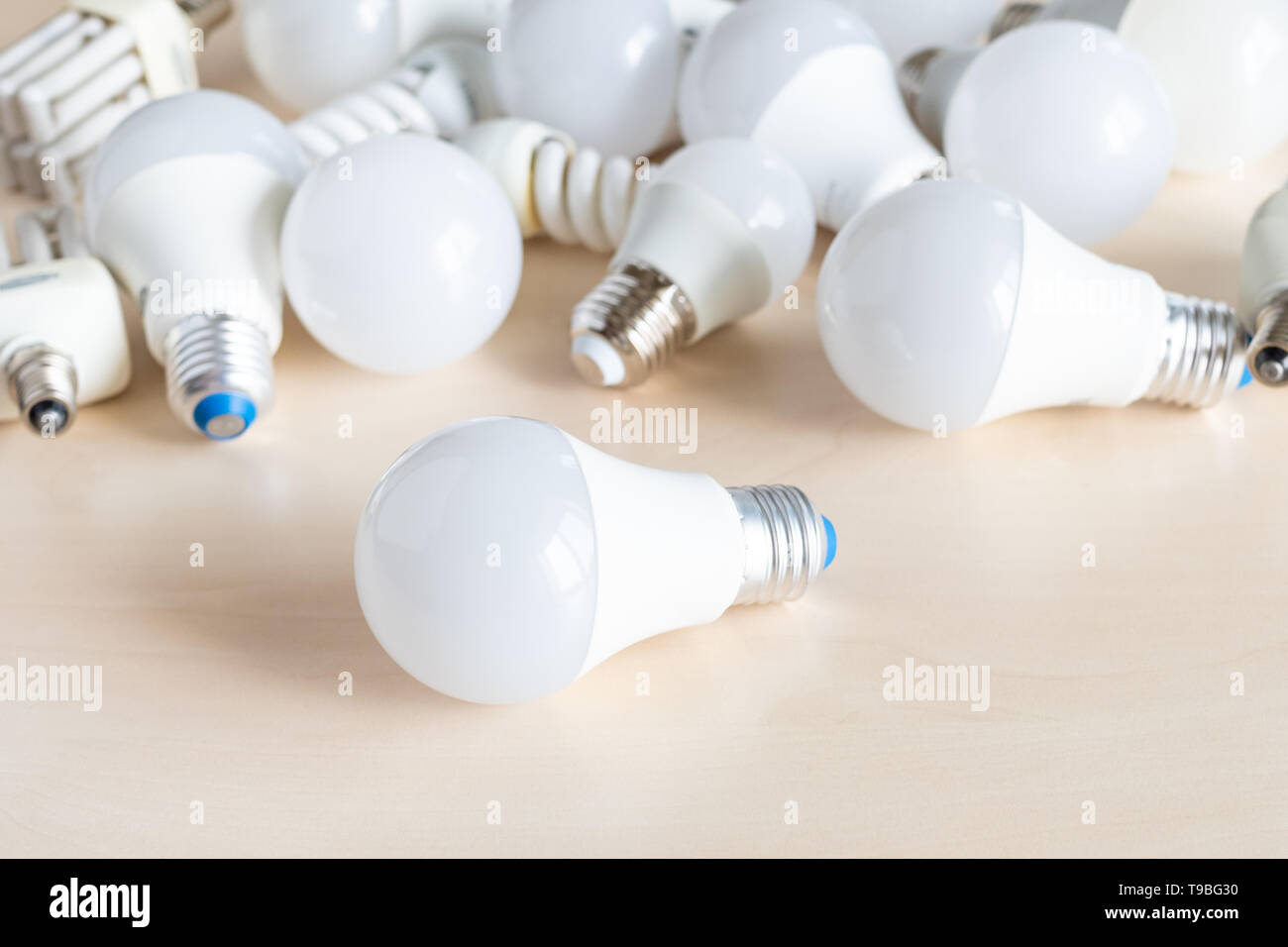 different LED bulb lights and energy-saving lamps on table Stock Photo