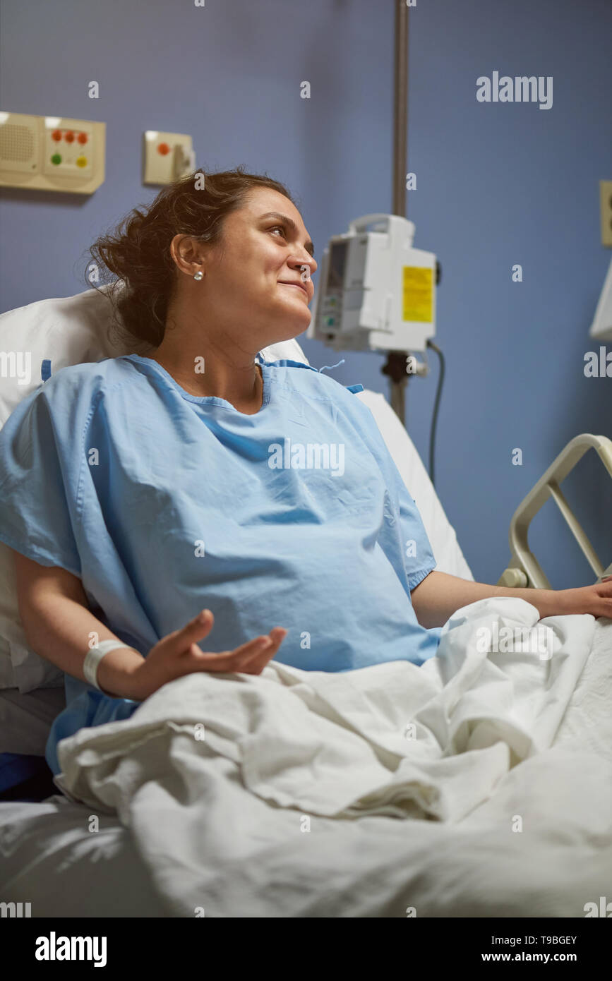 Young woman in clinic bed happy in recovery time Stock Photo
