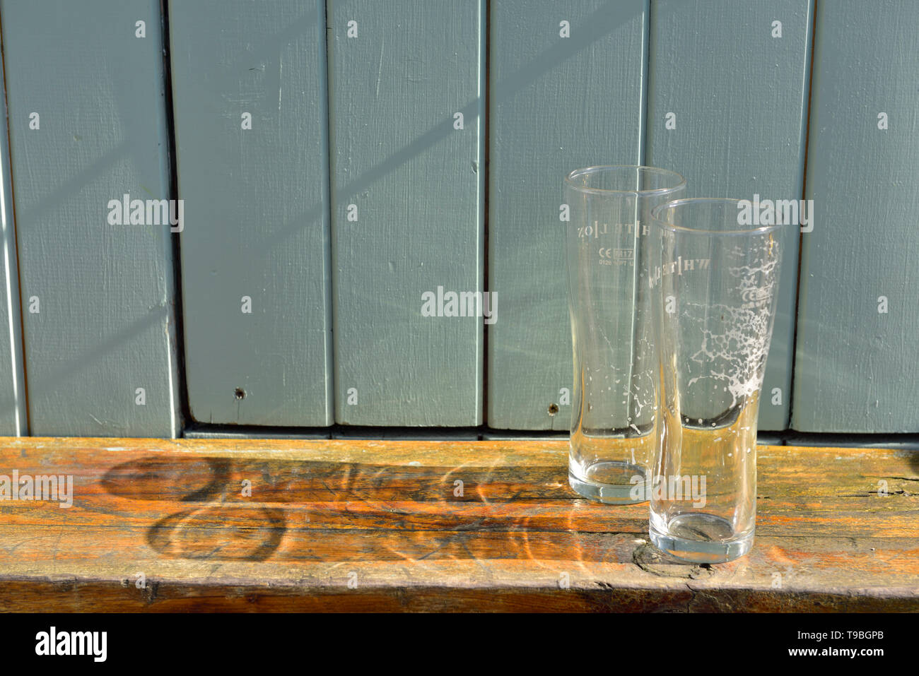 Two empty drinks glasses casting shadows Stock Photo