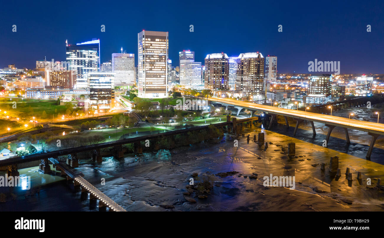 Walkways vehicle traffic bridges and railroad trestles traverse the river in front of Richmond Virginia Stock Photo