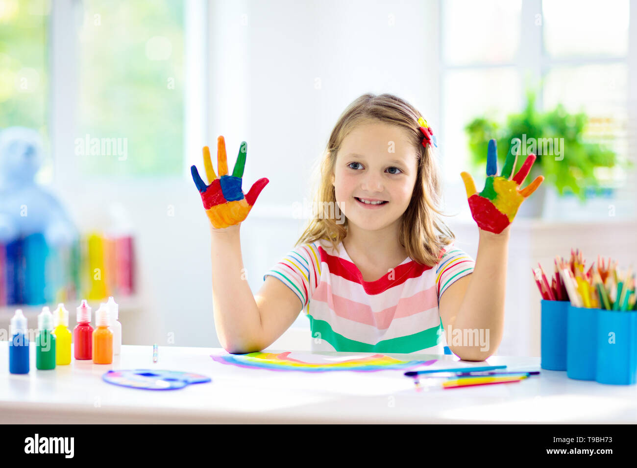 Kids Paint. Child Painting In White Sunny Study Room. Little Girl Drawing  Rainbow. School Kid Doing Art Homework. Arts And Crafts For Kids. Paint On  Children Hands. Creative Little Artist At Work.