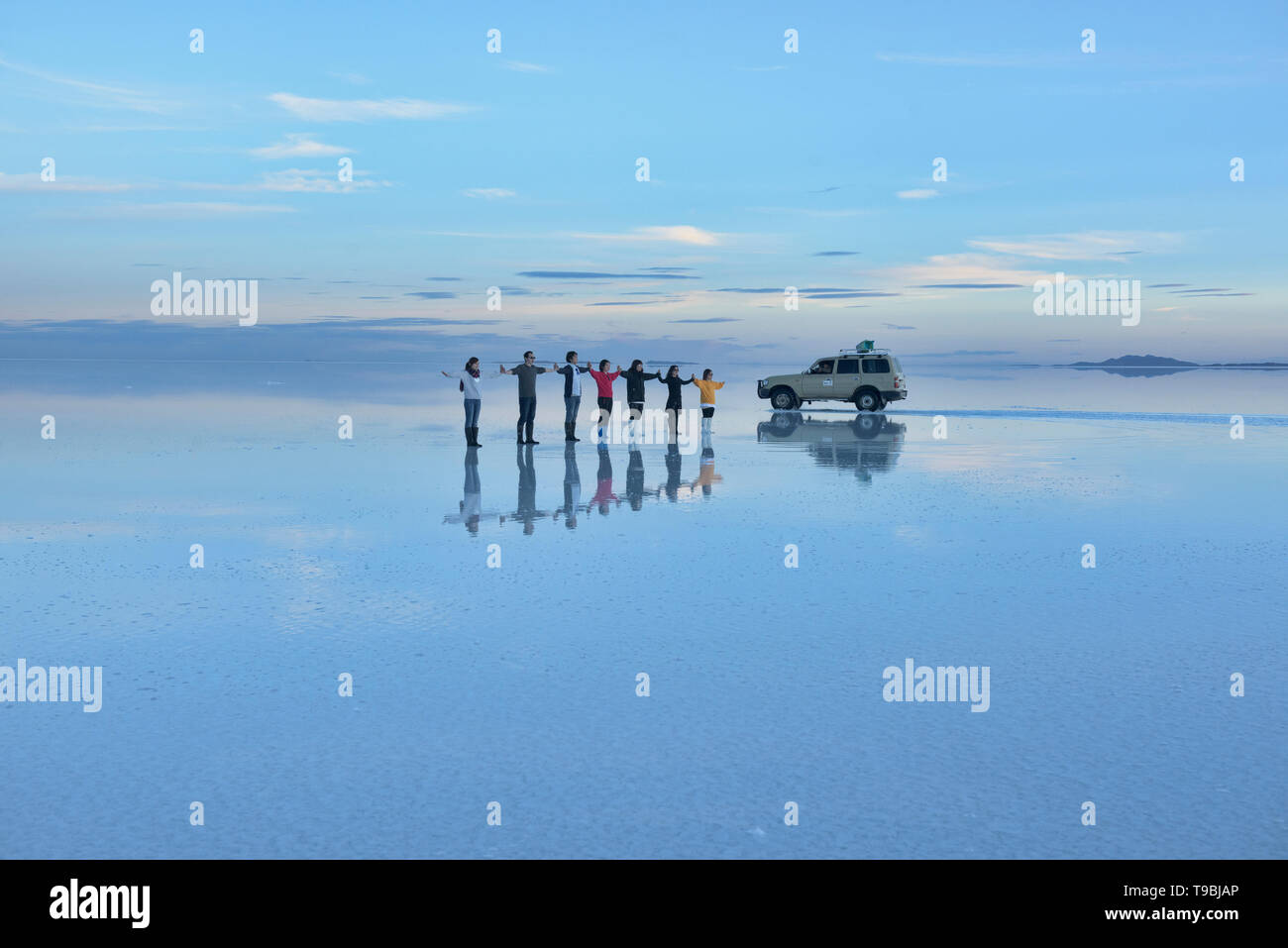 Tourists having fun on the world's largest mirror, the salt flats of the Salar de Uyuni, Bolivia Stock Photo