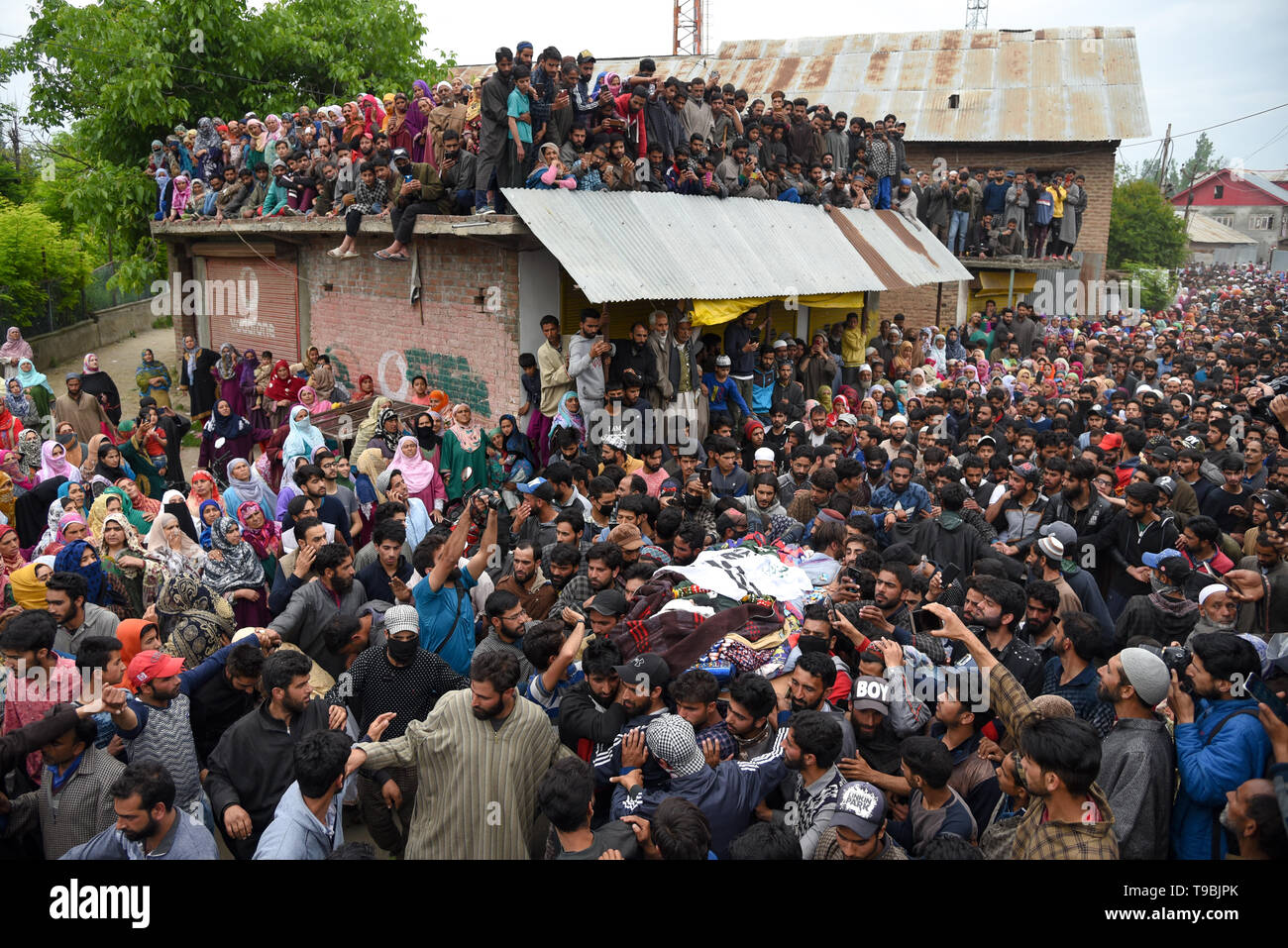 Kashmiri Muslim villagers seen gathered during the funeral procession of slain JeM Militant Naseer Ahmed Pandit at his residence in Pulwama, South of Srinagar. Three militants, an army man and a civilian were killed in a fierce gunfight that broke out in Dalipora area of Pulwama town in south Kashmir on Thursday morning. Stock Photo