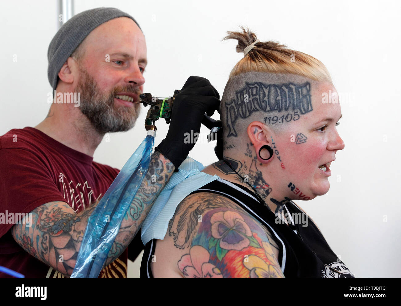 A tattoo artist is seen working on a participant during the Tattoo
