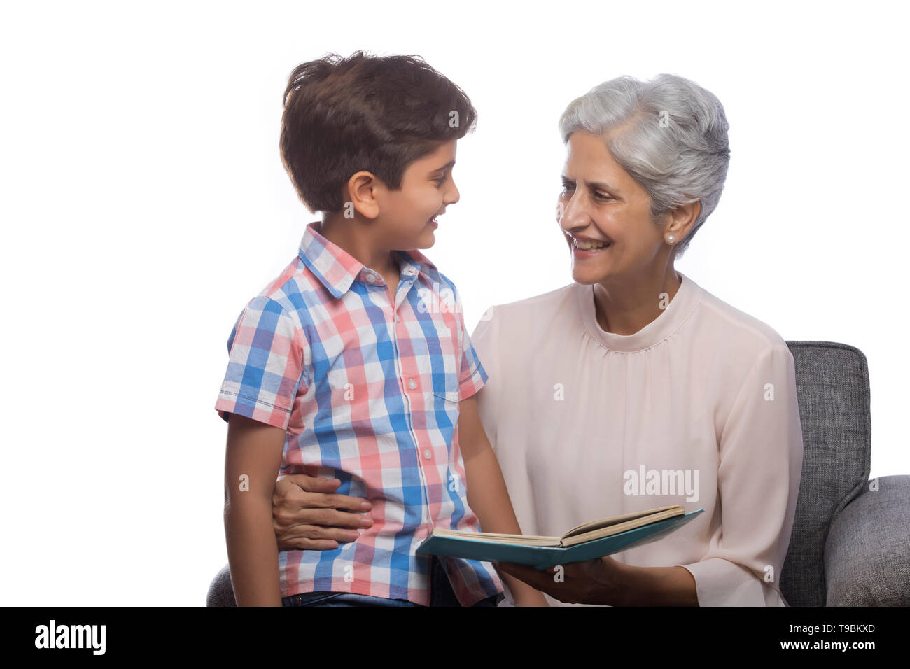 Grandmother reading book to her grandson Stock Photo