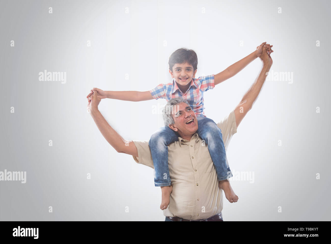 Grandfather carrying grandson on shoulders Stock Photo