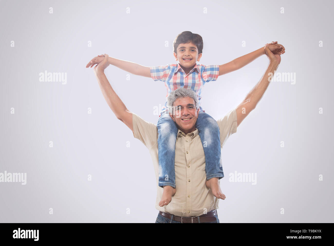 Grandfather carrying grandson on shoulders Stock Photo