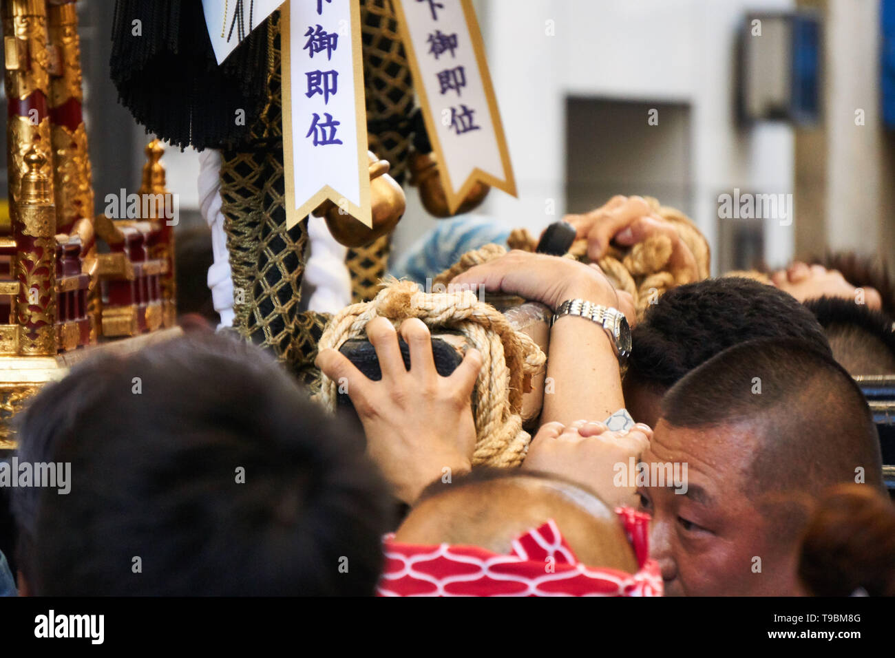 Japanese men carry or hoist up a mikoshi (omikoshi, portable shrine) during the Sanja Matsuri