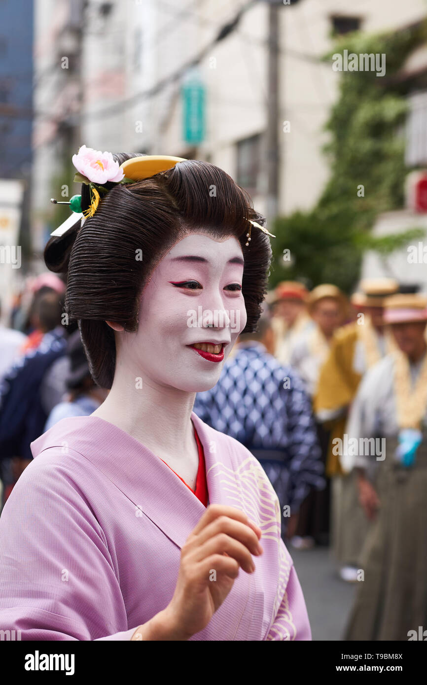 Middle-aged Japanese woman in traditional geisha attire (wig in tsubushi  shimada style, white makeup, red lipstick) and pink kimono at Sanja  Festival Stock Photo - Alamy