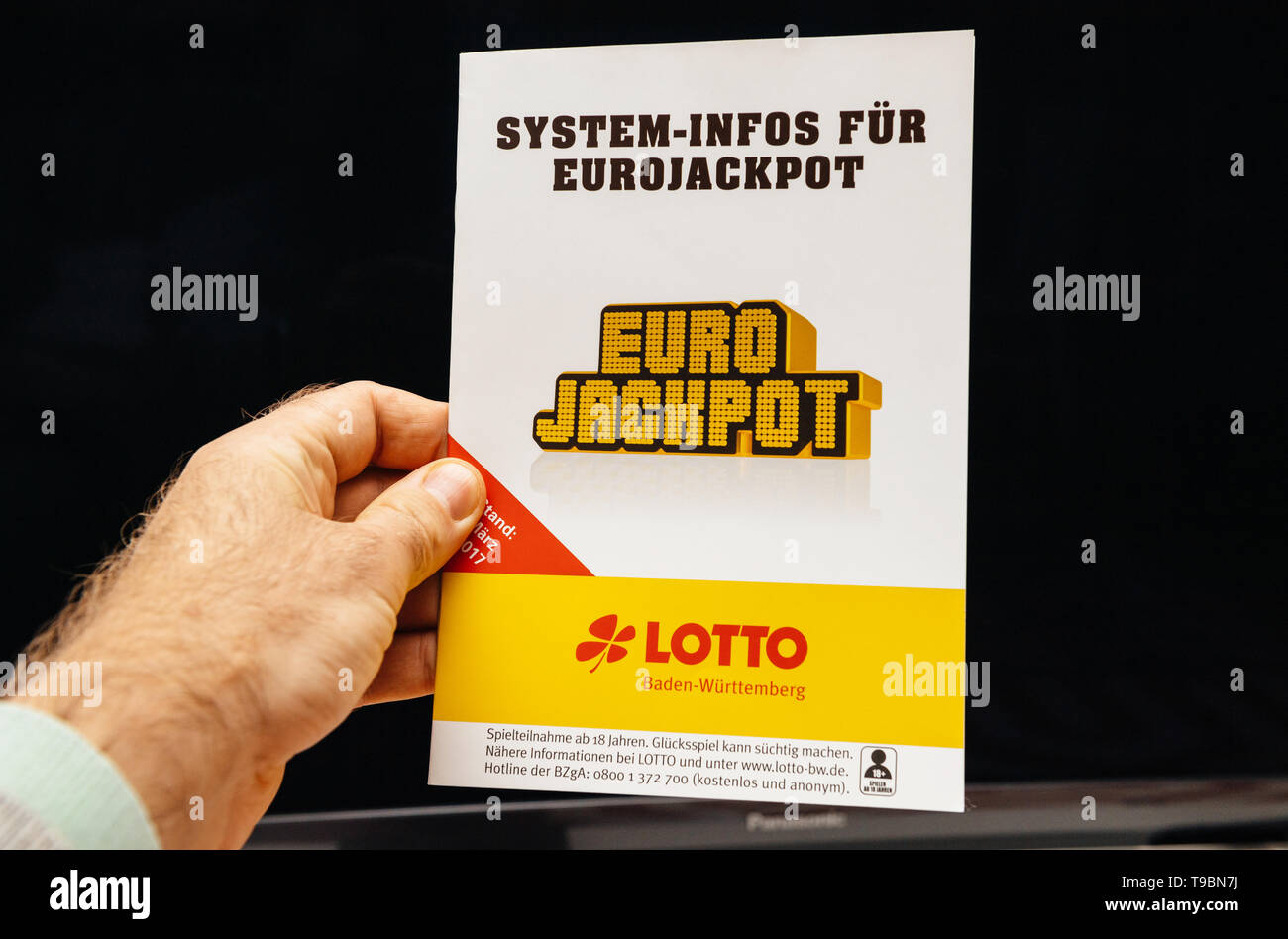 Frankfurt, Germany - April 9, 2019: Man hand holding against black  background instruction magazine Euro Jackpot by LOTTO Baden-Wurttemberg  Stock Photo - Alamy