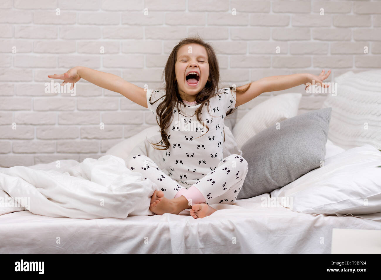 cute happy little child girl in pyjamas in bed. good morning Stock ...