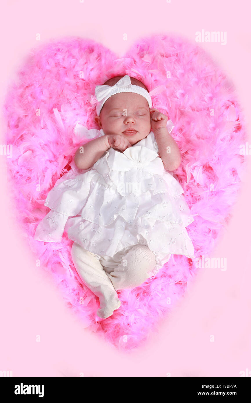 new born baby girl sleeping in pink feather bed Stock Photo Alamy
