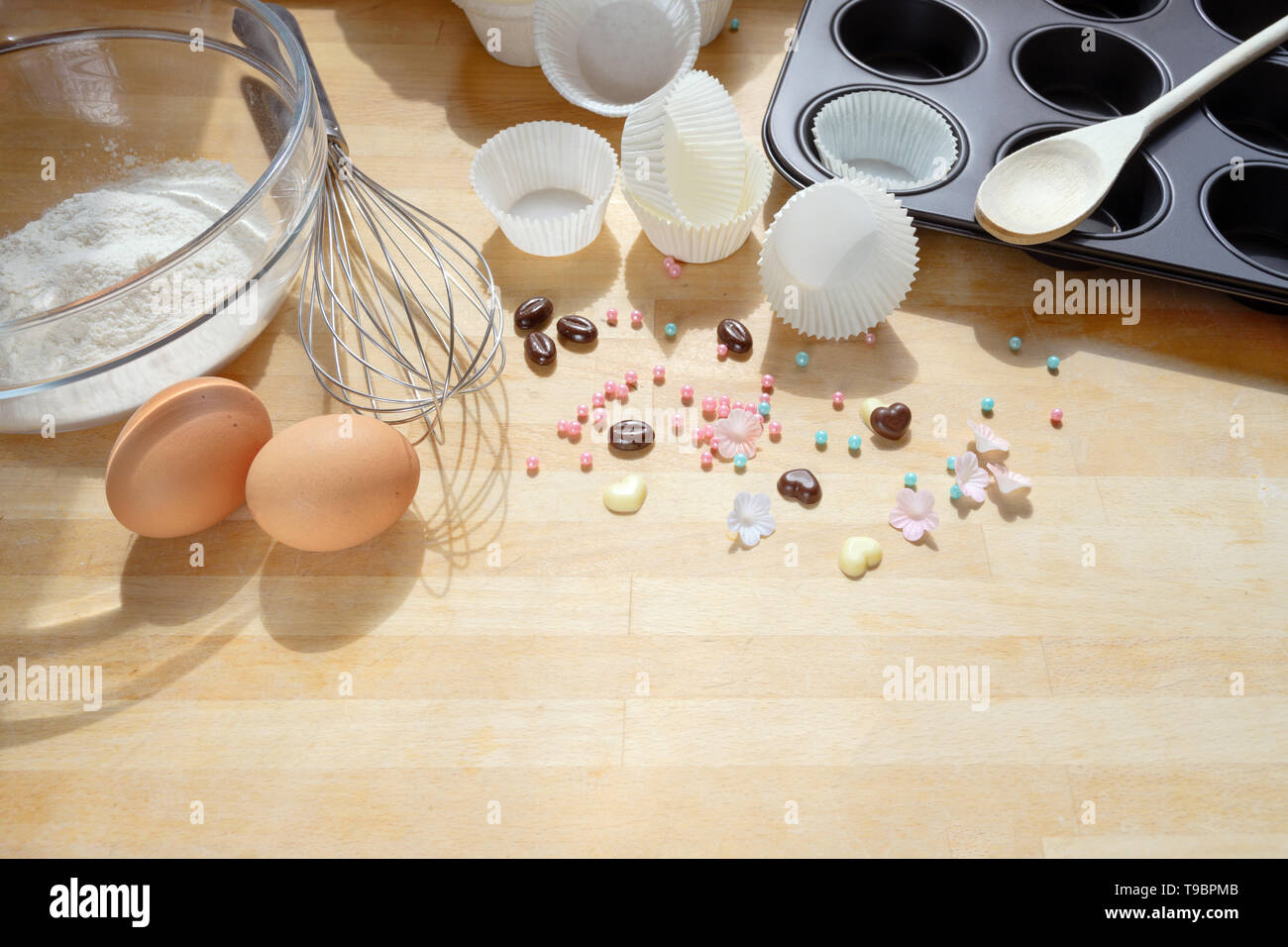 baking cupcakes, tools and ingredients on a wooden kitchen board, copy space, selected focus Stock Photo