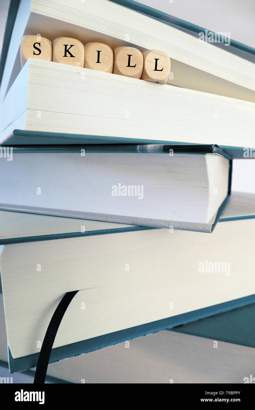 Skill message written in wooden blocks between pages of a book in a