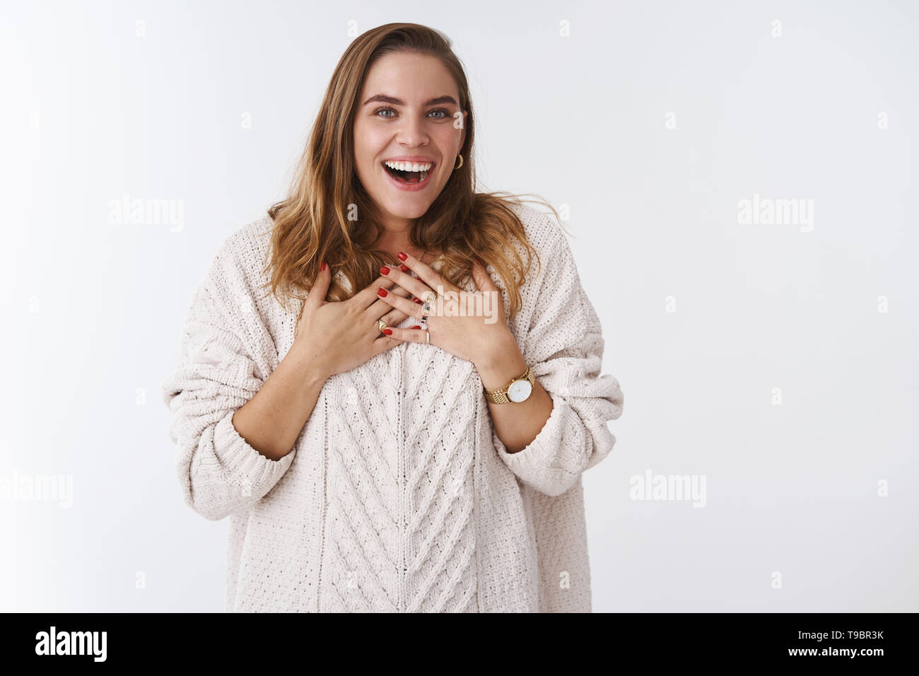 Surprised attractive charismatic caucasian woman wearing loose sweater reacting incredible pleasant unexpected gift smiling broadly speechless smiling Stock Photo
