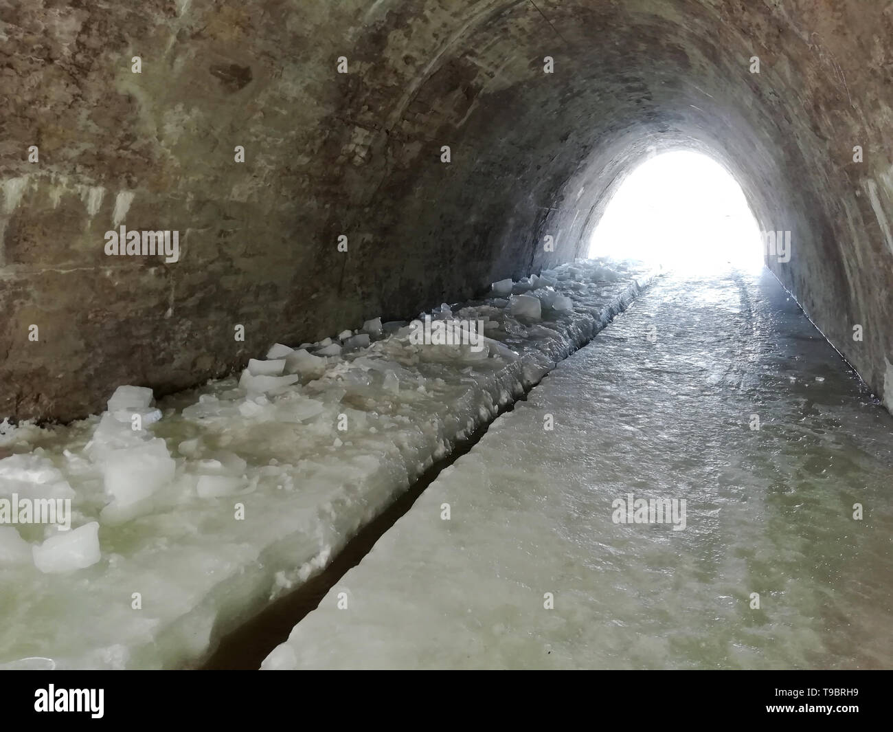Ice floor tunnel. Frozen water formed an icy floor under the tunnel. In