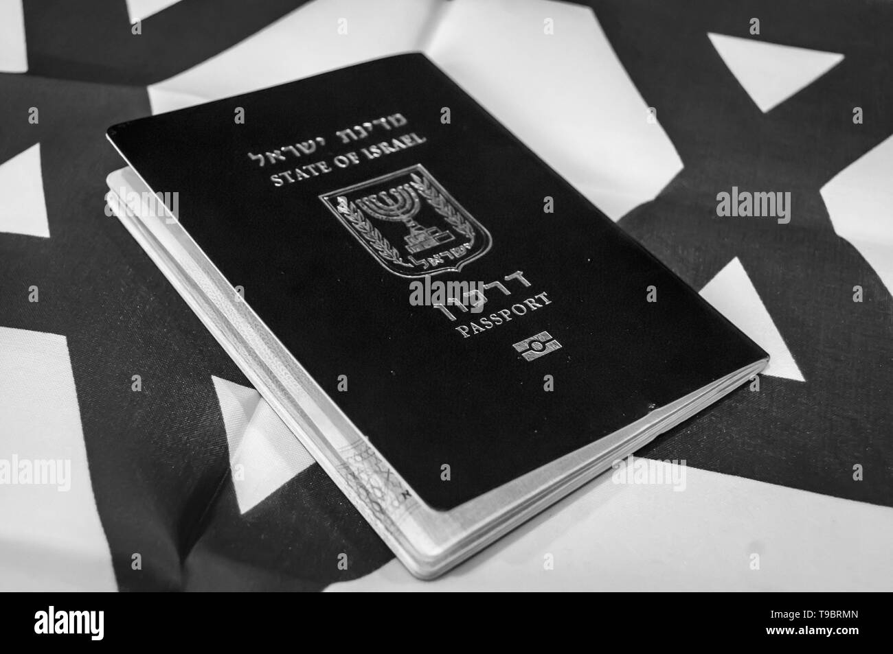 A blue passport of the State of Israel on Israeli flag on the background. Israel citizenship concept, Israeli biometric 'darkon' passport illustrative Stock Photo