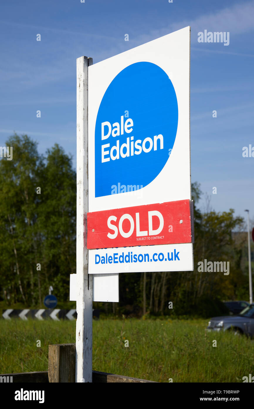 In bright, early morning, spring sunshine an Estate Agent's SOLD (subject to contract) sign proclaims a successful sales campaign. Stock Photo