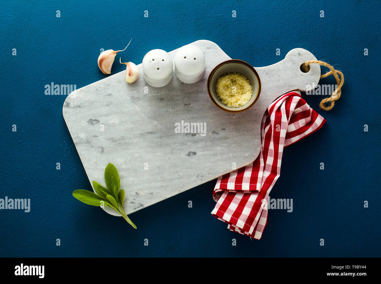 empty served plate on marble serving board and blue spice background Stock Photo