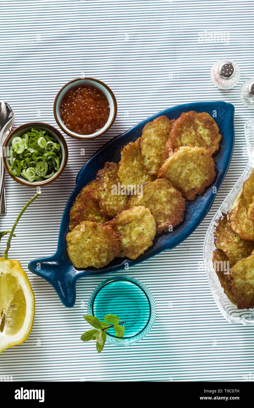 fish patties served on the table with red caviar, green onions and sour cream. fish homemade dish Stock Photo